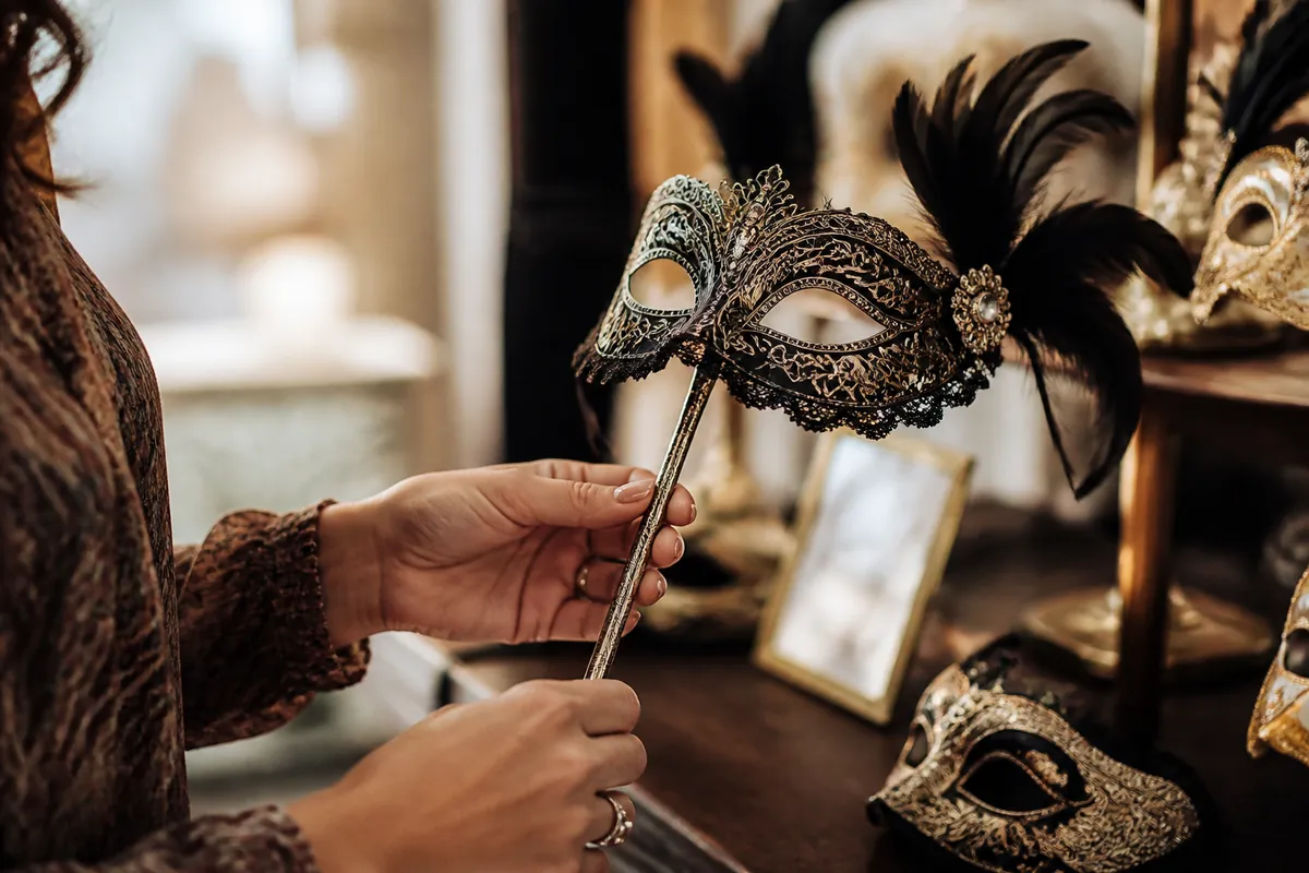 Person browsing a display of stick-mounted and tie-on masquerade masks